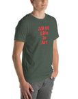 Angled view of man wearing heather forest Milk Sandwich T-shirt with bold red All Of Life Is Art text, modern unisex graphic tee with vintage font.