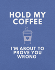 Close-up of true royal blue Milk Sandwich T-shirt with white bold text Hold My Coffee, I'm About to Prove You Wrong and a cute steaming coffee cup graphic.