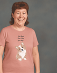 Smiling person with short curly hair wearing a pink t-shirt that features an illustration of a cute dog with the text “I’m high, can I pet your dog?” above it. Preguntar a ChatGPT