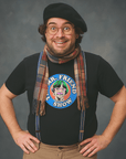 Smiling person wearing glasses, a beret, scarf, and suspenders with a black t-shirt featuring a colorful cartoon graphic of a character with green hair and the text “Mr. Friend Show.”