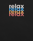 Close-up of a Milk Sandwich t-shirt featuring a stacked and mirrored relax text design in distressed white, blue, orange, and pink colors on black fabric.