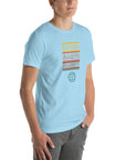 Man wearing a ocean blue Milk Sandwich t-shirt with a colorful "Round Earth Society" graphic printed vertically on the front.