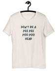 White t-shirt on hanger with bold blue text: “DON’T BE A PEE PEE POO POO HEAD”.