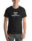 Man wearing a black t-shirt with the text ‘HIGH ON CREATIVITY’ in bold white capital letters, centered on the chest