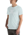 Man wearing a ice blue t-shirt with white text ‘HIGH ON CREATIVITY’, standing sideways with one hand in pocket
