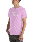 Man wearing a lilac t-shirt with white text ‘HIGH ON CREATIVITY’, standing sideways with one hand in pocket