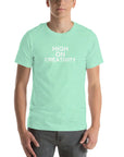 Man wearing a mint t-shirt with the text ‘HIGH ON CREATIVITY’ in bold white capital letters, centered on the chest
