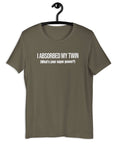 Army t-shirt hanging on a hanger with white text “I ABSORBED MY TWIN (What’s your super power?)” on the front.