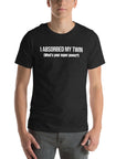 Man wearing black “I ABSORBED MY TWIN (What’s your super power?)” t-shirt, standing facing forward with hands relaxed.