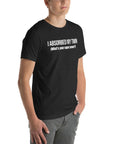 Man wearing black “I ABSORBED MY TWIN (What’s your super power?)” t-shirt, standing angled to the side with hands in pockets.