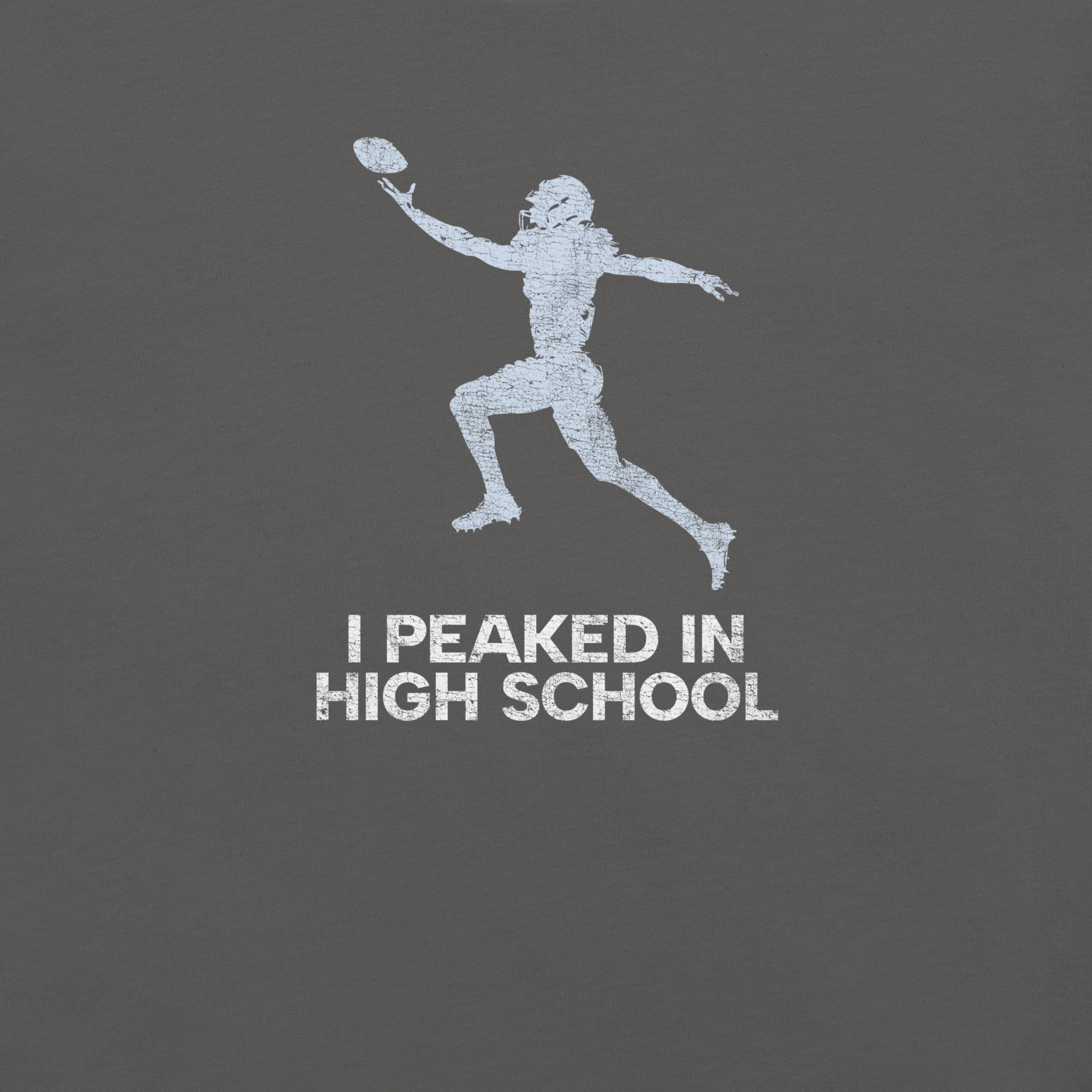 Close-up of asphalt Milk Sandwich T-shirt with distressed white football player graphic and text I Peaked in High School,  ironic athletic nostalgia tee.