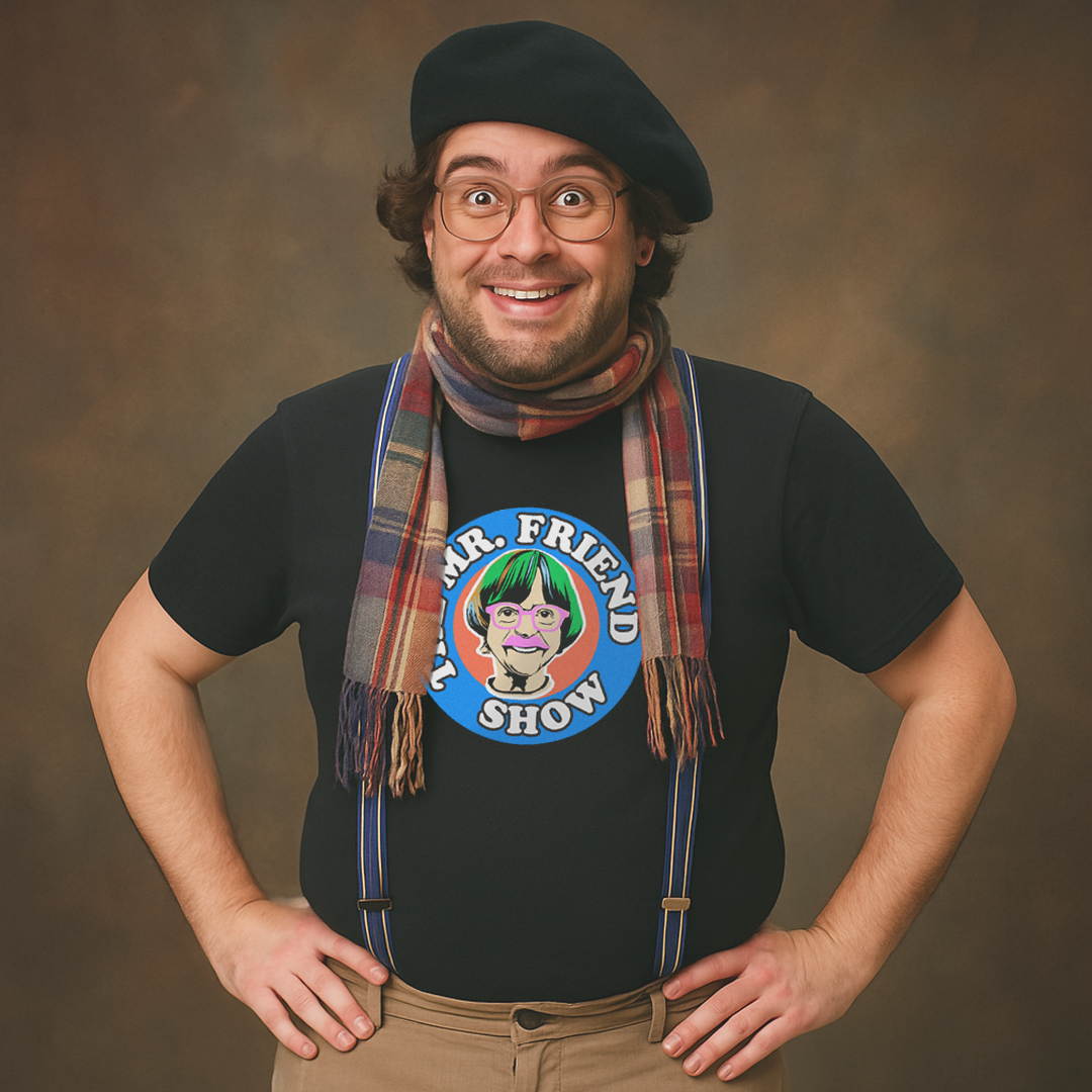 Cheerful man in beret and scarf wearing black Milk Sandwich T-shirt with colorful Mr. Friend Show cartoon graphic, quirky retro comedy tee.