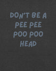 Man wearing dark grey “DON’T BE A PEE PEE POO POO HEAD” t-shirt, standing casually with hands by pockets.