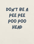 Man wearing white “DON’T BE A PEE PEE POO POO HEAD” t-shirt, standing casually with hands by pockets.