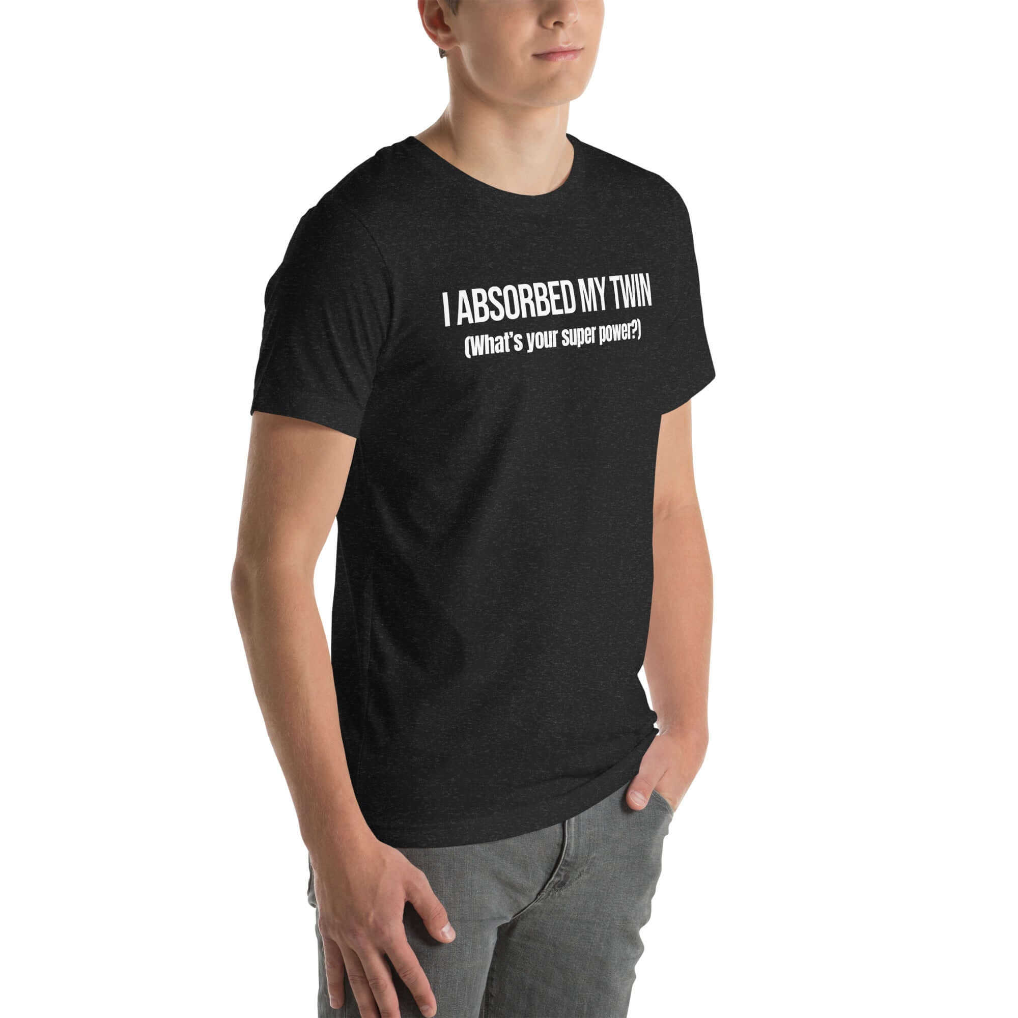 Man wearing black “I ABSORBED MY TWIN (What’s your super power?)” t-shirt, standing angled to the side with hands in pockets.