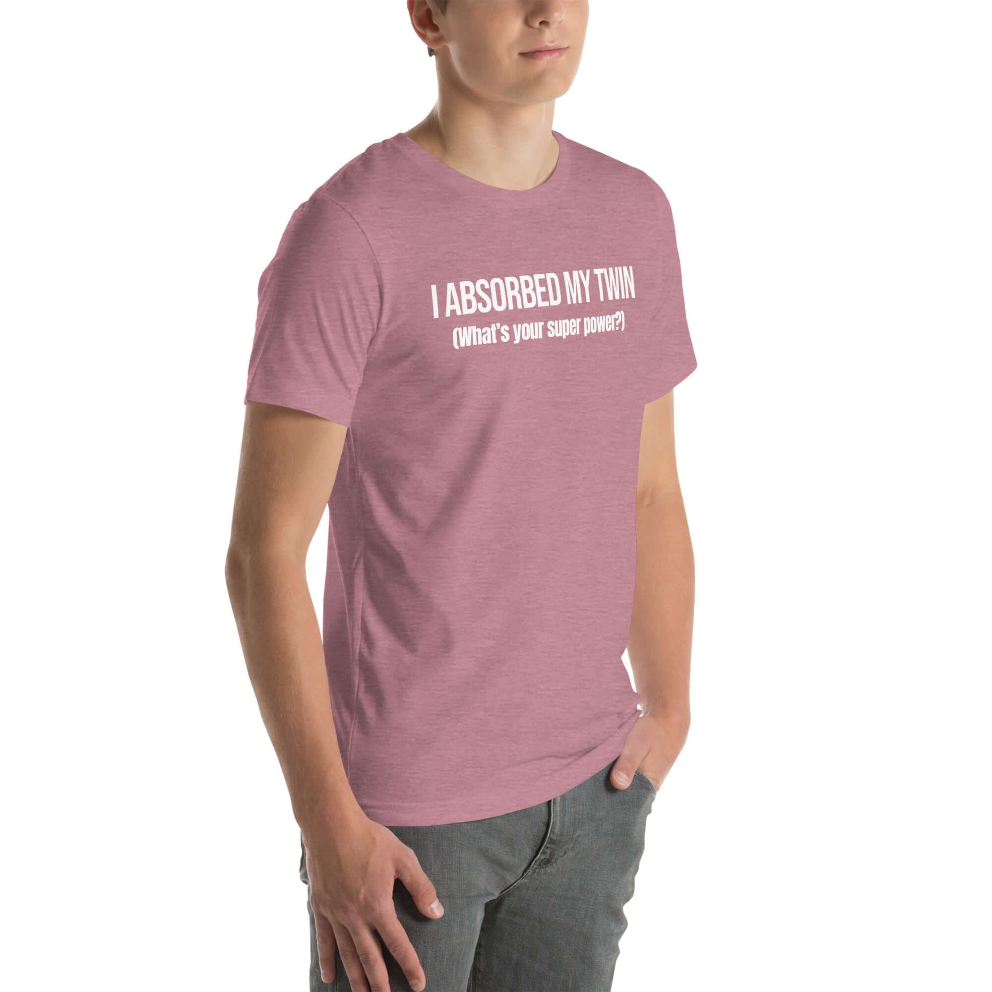 Man wearing orchid “I ABSORBED MY TWIN (What’s your super power?)” t-shirt, standing angled to the side with hands in pockets.