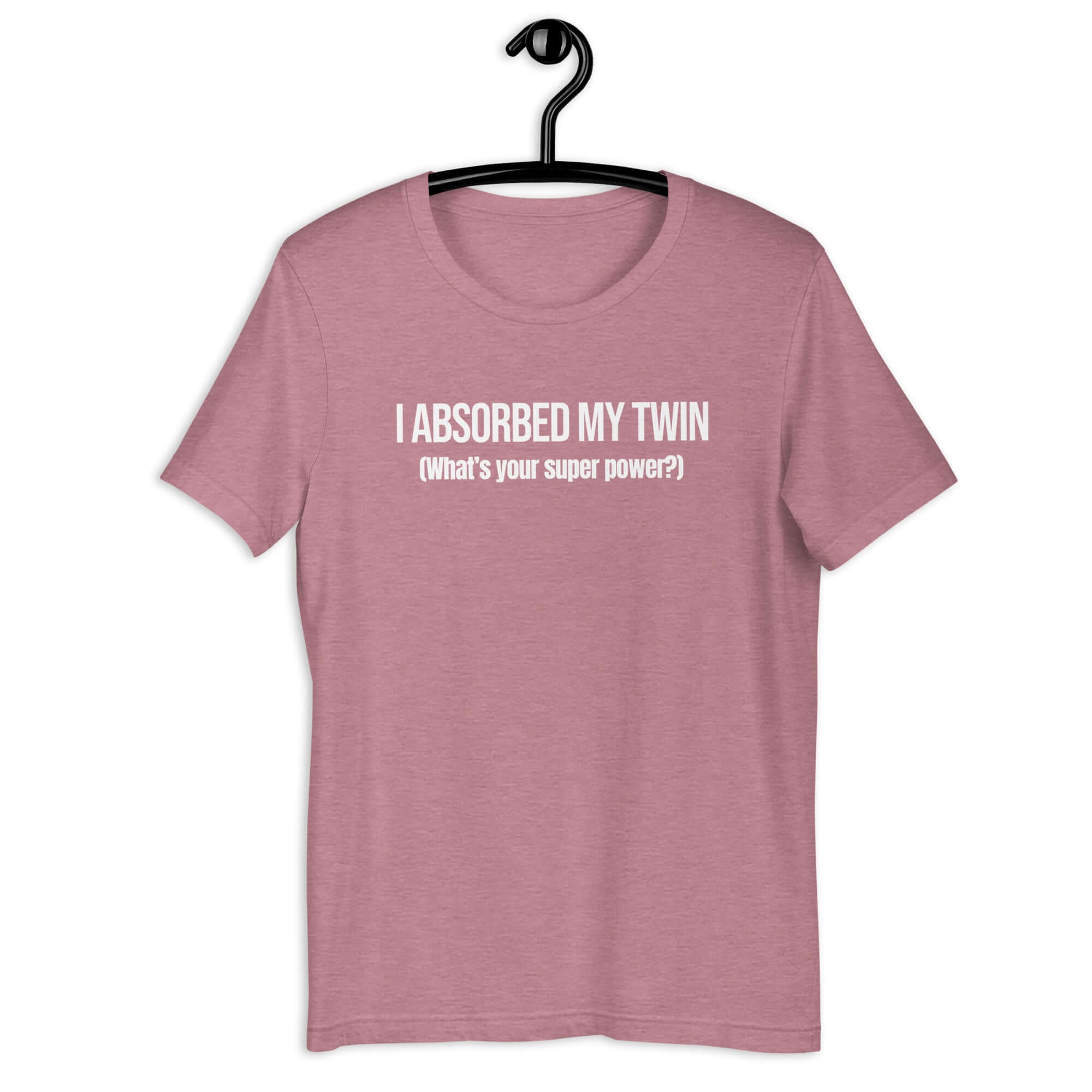 Orchid t-shirt hanging on a hanger with white text “I ABSORBED MY TWIN (What’s your super power?)” on the front.         