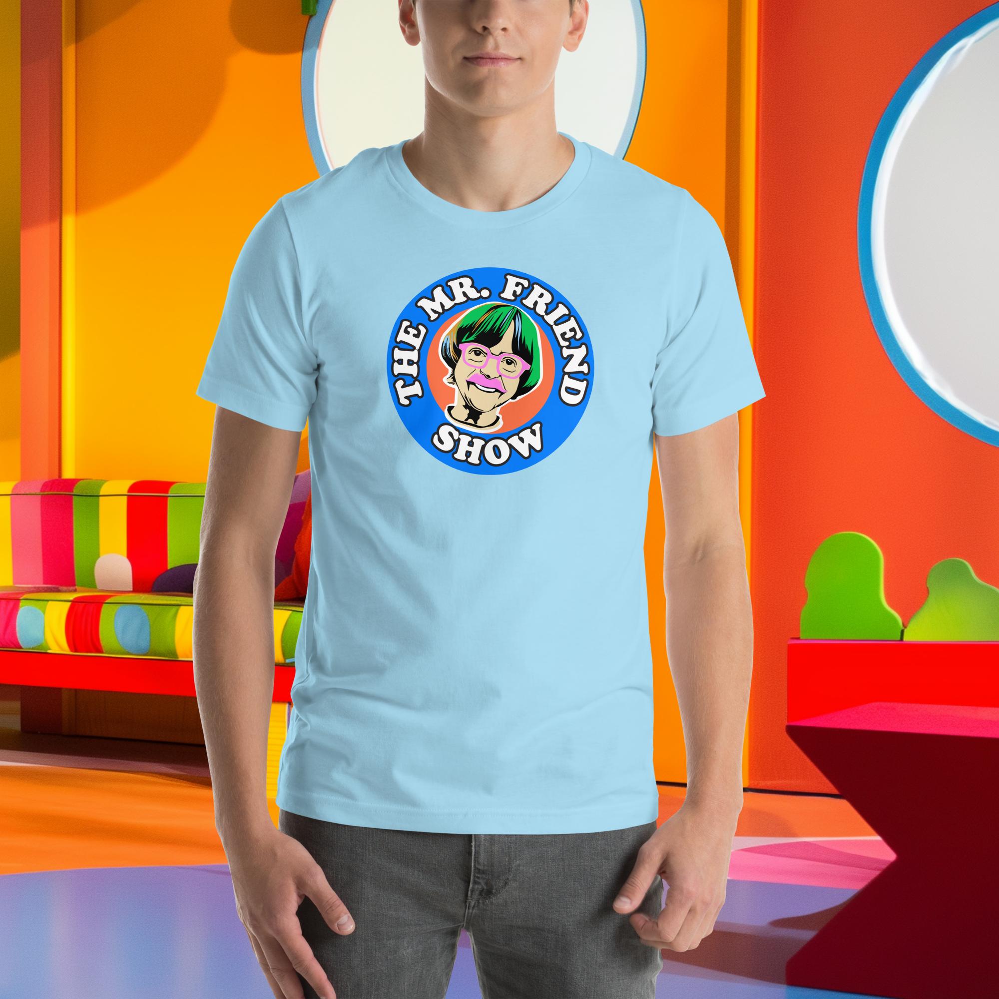 Light blue unisex t-shirt featuring "The Mr. Friend Show" graphic, worn by a person in a colorful room.